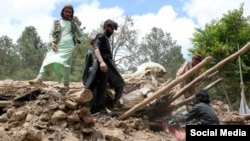 Afghans work to remove rubble from a house destroyed in the 6.10-magnitude earthquake that hit eastern Afghanistan on June 22. 