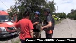 Volunteers try to convince one resident of Lysychansk to evacuateamid the constant Russian shelling.