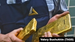 An employee holds cast bars of gold made by a company controlled by Polymetal.