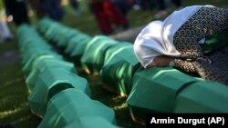 Боснійка плаче над труною з останками члена її сім’ї, який є одним із 50 нещодавно ідентифікованих жертв геноциду в Сребрениці. Місце поховання жертв Сребриниці у Поточарі. Боснія і Герцоговина. 11 липня 2022 року