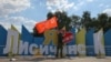 A Russian-backed separatist holds a Soviet-era flag, which was raised to mark the anniversary of the victory over Nazi Germany in World War II at the &quot;I love Lysychansk&quot; monument on July 4 after Ukrainian forces were forced to withdraw.