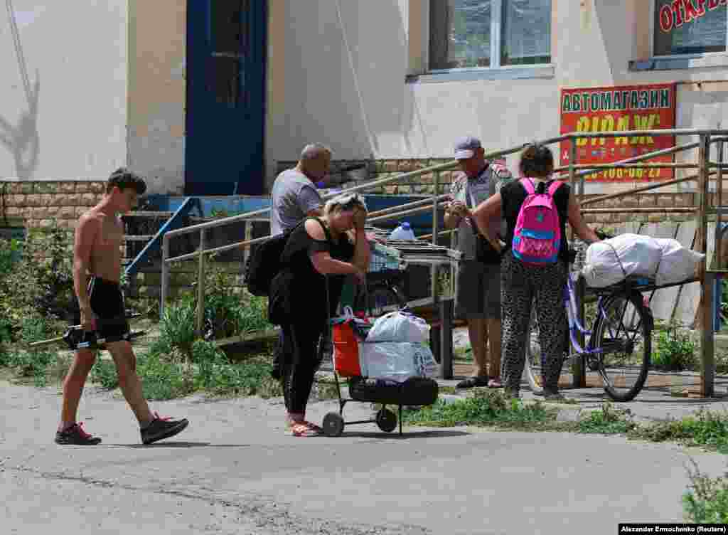 Stanovnici Lisičanska čekaju sa svojim stvarima da budu evakuisani iz uništenog grada.