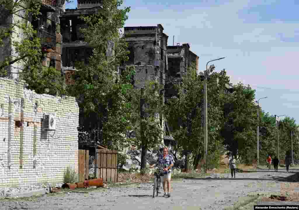 После нескольких месяцев артиллерийских ударов жители выходят из подвалов и ходят по руинам Северодонецка