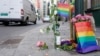 Steag în culorile curcubeului și flori în semn de omagiu pentru victimele atacului din capitala norvegiană Oslo, 25 iunie 2022.
