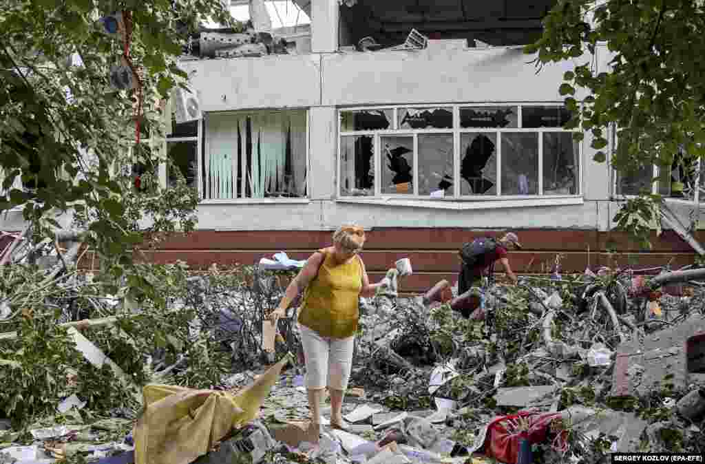 Жители Харькова разгребают завалы после того, как российская ракета разбила здание школы 10 июля