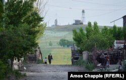 Locals in Akhurik, a village near Gyumri on the Turkish border. An Armenian border watchtower can be seen in background.