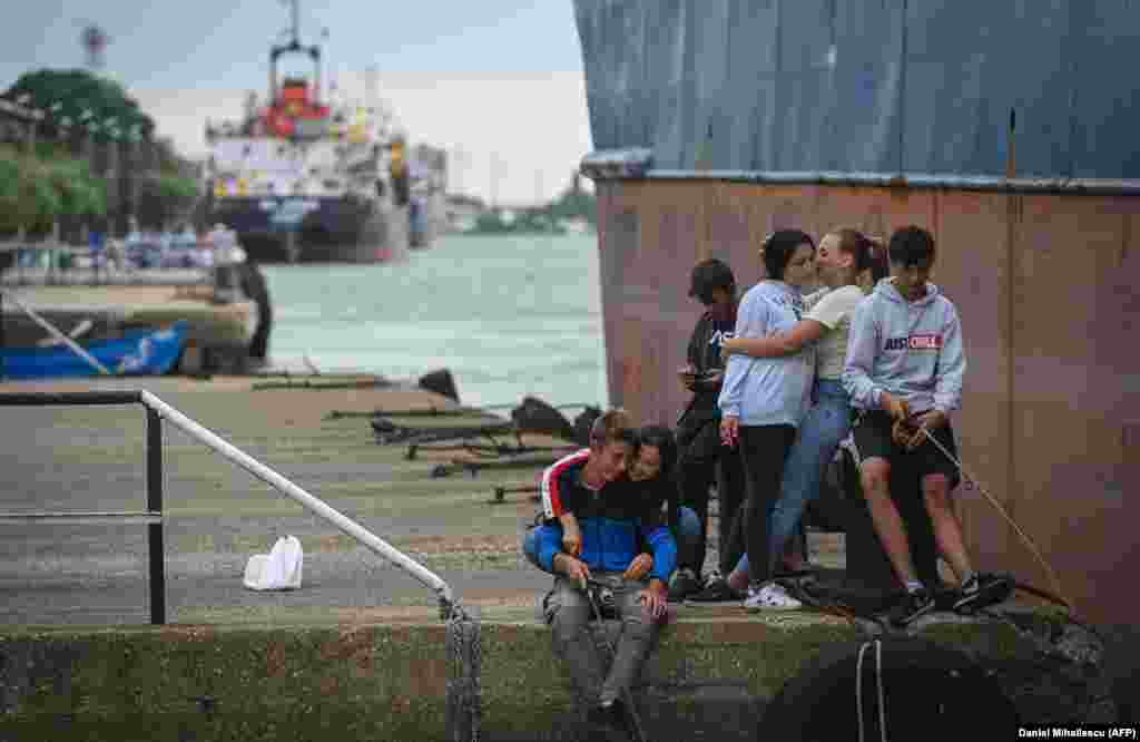 Young locals relax at a port on the Sulina Canal.&nbsp; International observers warn that a food crisis is looming as a result of Moscow&#39;s invasion of Ukraine, especially in some African countries that rely mostly on shipments from Russia and Ukraine for their grain supply. The UN has warned of a &quot;hurricane of hunger&quot; if grain transport out of Europe cannot be sped up.&nbsp; &nbsp;