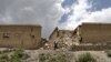 A man in Afghanistan's Gayan district walks past a house damaged in the recent quake. (file photo)