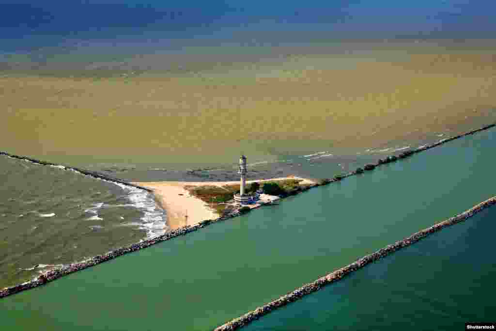 The Sulina Canal where it enters the Black Sea According to a June 17 AFP report, nearly 100 boats are currently queueing to enter the canal as nearby Ukrainian ports remain blocked due to the presence of Russian naval vessels on a war footing in the Black Sea.