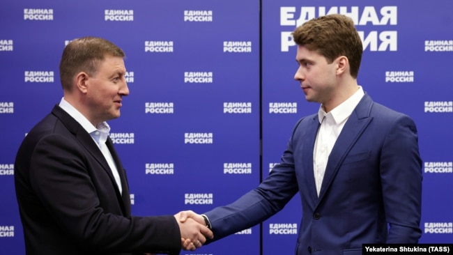 Секретарят на Генералния съвет на „Единна Русия“ Андрей Турчак (вляво) връчва членска карта на партията на Иля Медведев, синът на Дмитрий Медведев,