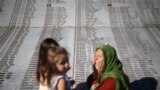 Žena se moli pored spomenika sa imenima ubijenih u genocidu u Srebrenici, Memorijalni centar Potočari, BiH, 10. juli 2022.