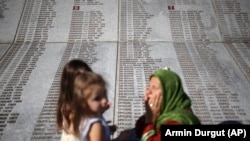Žena se moli pored spomenika sa imenima ubijenih u genocidu u Srebrenici, Memorijalni centar Potočari, BiH, 10. juli 2022.