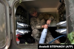 Egy ukrán katona tüzérségi támadásra készül Liszicsanszk város közelében június 14-én