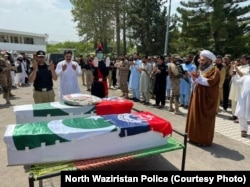 Men offer funeral prayers for two police officers killed in militant attacks in North Waziristan on June 28.