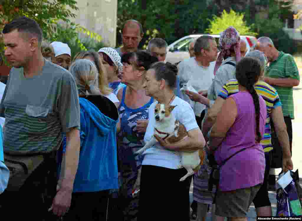 Local residents gather to receive food distributed by volunteers. The United Nations Office For the Coordination of Humanitarian Affairs (OCHA) called the situation in&nbsp;Syevyerodonetsk &quot;dire&quot; as humanitarian assistance is restricted, if not impossible.