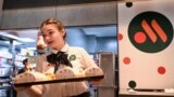 RUSSIA-UKRAINE-CONFLICT-ECONOMY-MCDONALDS -- An employee holds a food order on a tray in the Russian version of a former McDonald's restaurant after the opening ceremony in Moscow on June 12, 2022. - Former McDonald's restaurants in Russia have been renam