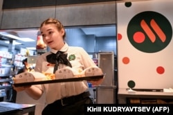Un angajat cu o comandă de mâncare pe o tavă în restaurantul „Vkusno i tochka" versiunea rusească a unui fost McDonald's, 12 iunie 2022
