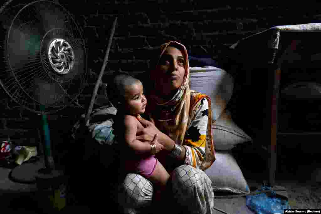 Razia and her daughter Tamanna sit in front of a fan to cool off during the sweltering heat on May 15. The United Nations Office for the Coordination of Humanitarian Affairs (OCHA) released a report on Pakistan&#39;s long-term prospects, painting a bleak picture of problems that the country will face, such as longer, more intense heat waves, droughts, and an increase in poverty. As food production declines, women and children will be more vulnerable to malnourishment and malnutrition.