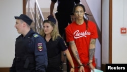 U.S. basketball player Brittney Griner, who was detained in March at Moscow's Sheremetyevo Airport and later charged with illegal possession of cannabis, is escorted before a court hearing in Khimki, outside Moscow, on July 7.