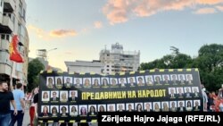 Protestuesit në Shkup e vendosin para Kuvendit të Maqedonisë së Veriut pankartën me fytyrat e deputetëve të shumicës parlamentare, në të cilën shkruhet "Tradhtarë të popullit ". Shkup 6 korrik 2022.