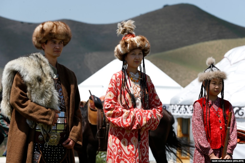 Кыргызы в национальной одежде&nbsp;на фоне белых юрт и живописных степей