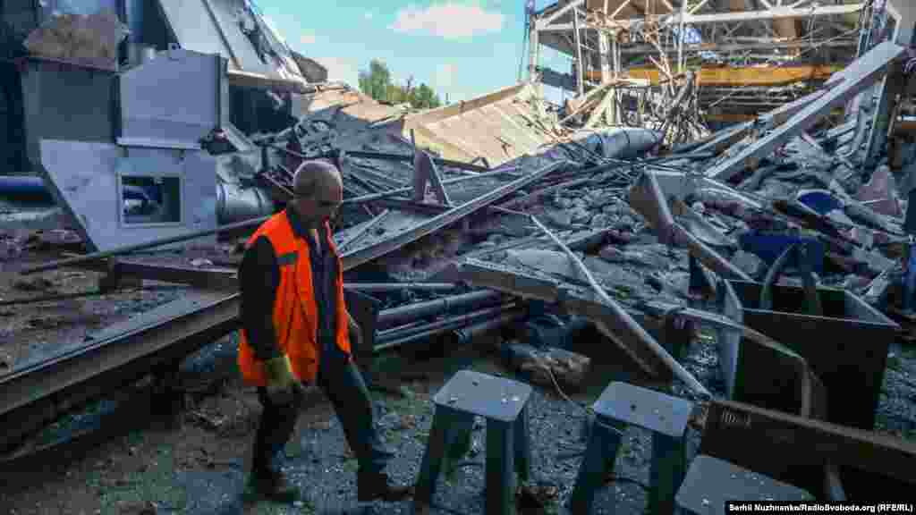 Працівник йде зруйнованим виробничим цехом заводу дорожніх машин (&laquo;Кредмаш&raquo;), який був зруйнований внаслідок ракетного удару 27 червня