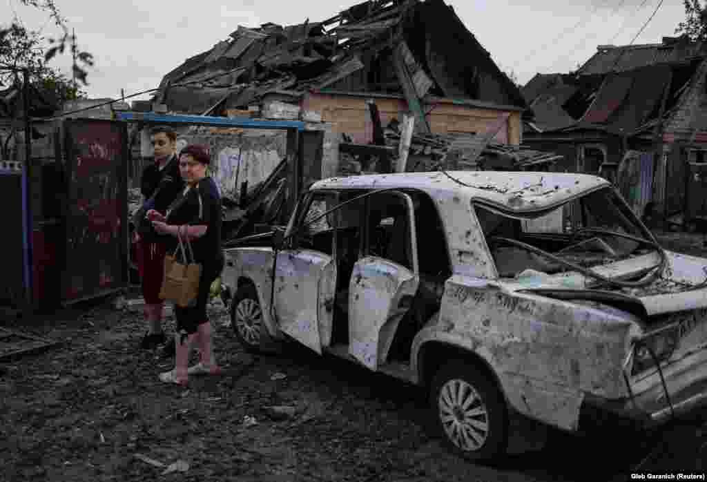 Helyi lakosok egy orosz rakétacsapás által lerombolt épület mellett Pokrovszk városában, a Donyecki régióban június 15-én