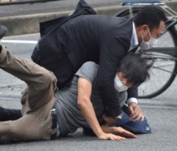 Охранник Синдзо Абэ удерживает стрлявшего в бывшего премьера Тэцуя Ямагами. Город Нара, утро 8 июля 2022 года