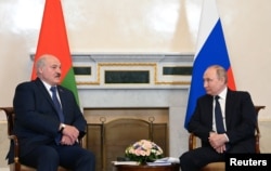 Russian President Vladimir Putin (right) meets with Belarusian strongman Alyaksandr Lukashenka in St. Petersburg on June 25.