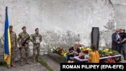 Ukrain esger Ýewhen Olefirenkonyň ejesi Oksana we onuň gyzy Dzwenyslawa esgeriň Kiýewde geçirilen jenaza çäresine gatnaşyp, ýas tutýarlar. 9-njy iýul, 2022 ý. Kiýew ş. Ukraina.