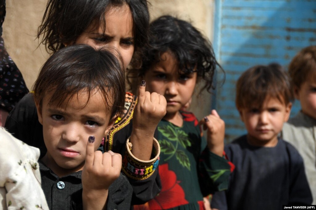 Disa fëmijë në Pakistan tregojnë gishtat e tyre të lyer me ngyrë pasi kanë marrë vaksinën kundër poliomielitit në Kandahar, më 28 qershor.