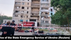Body bags containing the remains of some of the 21 civilians killed by a Russian missile strike lie in front of a damaged residential building in the village of Serhiyivka on July 1.
