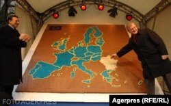 Aderarea Romaniei la UE a fost marcată simbolic printr-o hartă căreia i s-a alăturat și harta României, respectiv a Bulgariei. În imagine: Olli Rehn, comisarul european pentru extindere și Jose Manuel Durao Barroso, presedintele Comisiei Europene din 2006.
