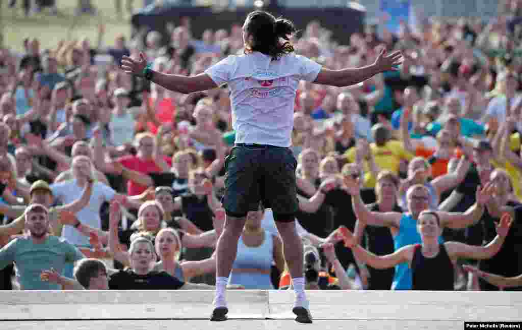 Fitness trener Joe Wicks usmjerava gomilu učesnika u pokušaju da obore svjetski rekord u najmasovnijem treningu u Hyde Parku, London, Velika Britanija, 29. juni 2022.