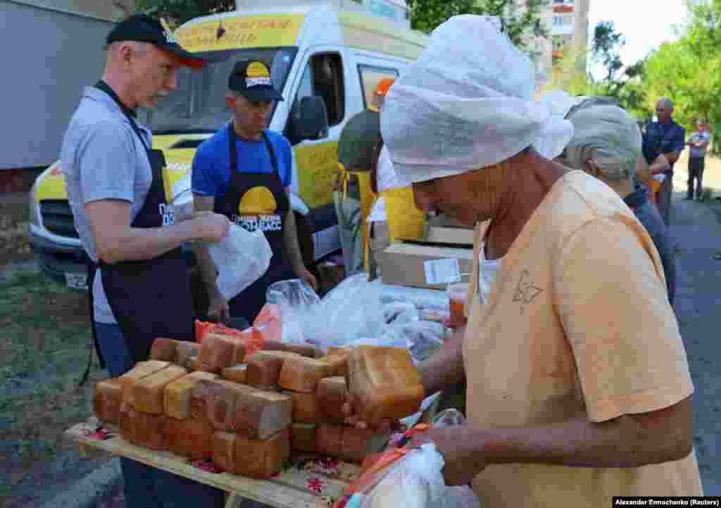 Mai mulți voluntari distribuie hrană localnicilor din Severodonețk, 30 iunie 2022.