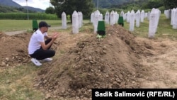 Босния жана Герцеговинада Сребреница шаарында кайрадан көмүлгөн сөөктөрдүн жанында олтурган киши. 11-июль, 2022-жыл.