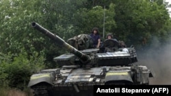 Ushtarët ukrainas ngasin një tank në një rrugë të rajonit lindor të Luhanskut më 23 qershor 2022.