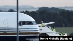 Članovi posade se ukrcavaju u avion za koji su britanski mediji javili da je prvi kojim je trebalo da budu prevezeni migranti u Ruandu, baza u Wiltshireu, Velika Britanija, 14. juni 2022.