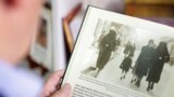 Eli Tauber shows a picture in a book of Rifka Kabiljo and Zeineba Hardaga walking on a street in Sarajevo in 1941, in Sarajevo, Bosnia and Herzegovina, June 13, 2022. Picture taken June 13, 2022.