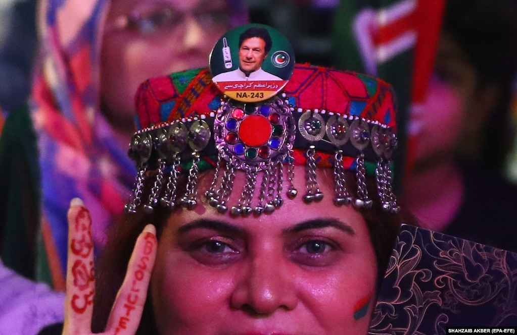 Mbështetësit e partisë opozitare Pakistani Tehrik-e Insaf duke dëgjuar liderin e partisë dhe ish-kryeministrin Imran Khan gjatë një tubimi në Karaçi, më 19 qershor.