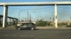 Kazakhstan -- The car seen on the road on the background of smoking AMT metallurgical plant. Temirtau, June 17, 2022