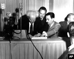 Izraelski premijer Ben Gurion (lijevo) potpisuje dokument u Tel Avivu kojim se proglašava Jevrejska država Izrael, maj 1948.