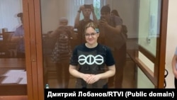 Csaniseva mosolyog a kameráknak a ketrecéből a moszkvai Baszmanszkij bíróságon 2022 júliusában
