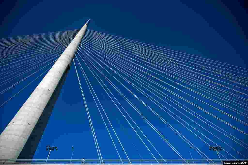A man rides a bicycle over Ada Bridge in Belgrade. Built in 2012, the bridge connects the municipalities of Cukarica and New Belgrade. (AFP/Andrej Sakovic)