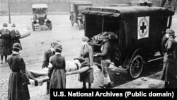 США, місто Сент-Луїс у штаті Міссурі, 1918 рік. Представники Червоного Хреста у масках винесли з будинку для подальшого транспортування жертву іспанського грипу (іспанки)