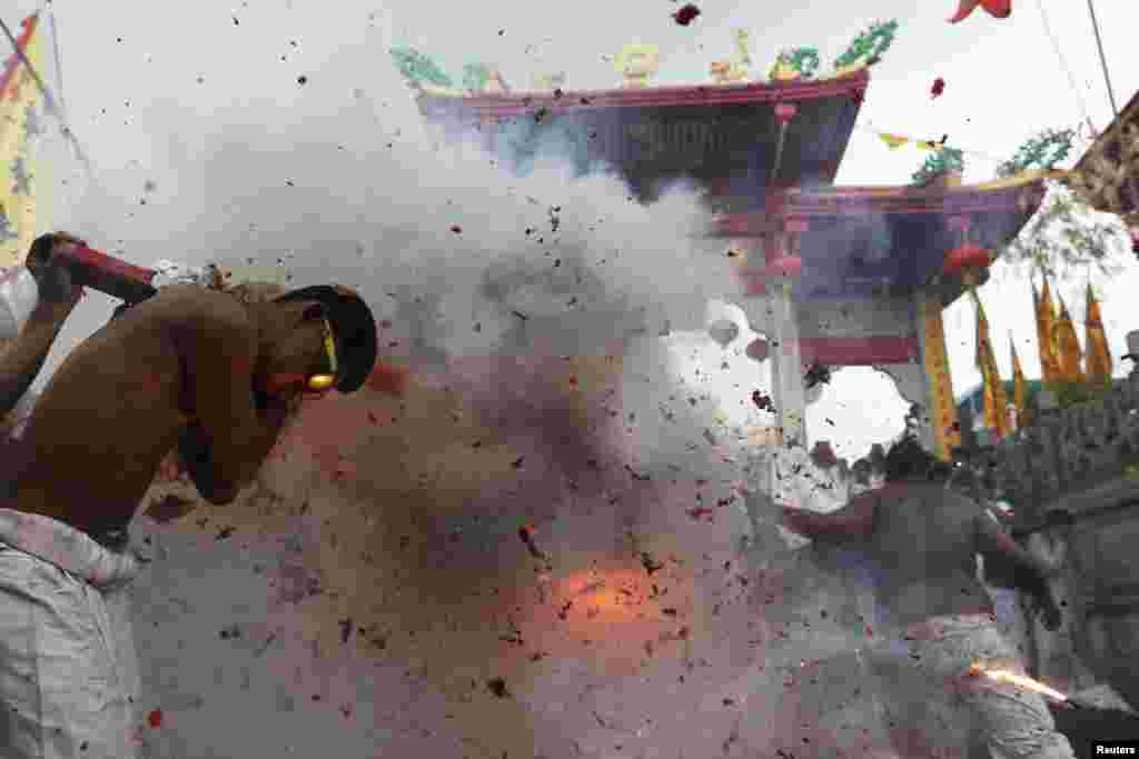 Firecrackers explode as devotees of the Chinese Jui Tui Shrine in Thailand return the statue after it had been taken on a procession celebrating the annual vegetarian festival in Phuket on September 30. (Reuters/Damir Sagolj)