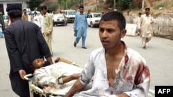 A man pulls a stretcher carrying bomb blast victims outside a hospital in Peshawar.