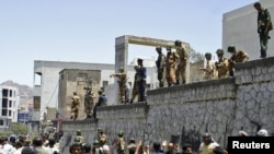 Soldiers and police stand guard during clashes between antigovernment protesters and supporters of Yemeni President Ali Abdullah Saleh in the southern city of Taiz on April 5.