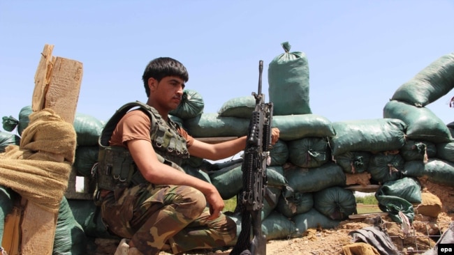 Afghanistan -- A member of the Afghan security forces takes up a position during an operation against Taliban fighters in Nad Ali district of Helmand province, April 27, 2016