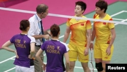 An official speaks to players from China and South Korea during their women's doubles badminton group match on July 31.